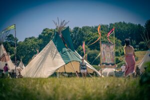 Hearthworks 30ft diameter Sunlodge Tipi with rolled up entrance being used as a workshops space in the Glastonbury Festival Tipi Field