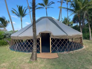 Exterior of 30ft diameter Giant Hearthworks Yurt pitched for a special event in the Caribbean amidst palm trees and with the canvas walls removed